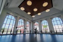 Dancers practicing in front of large windows in large dance studio